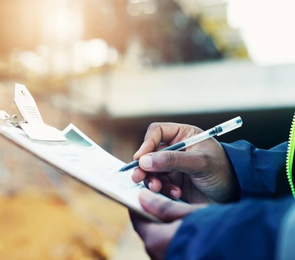 Inspector recording maintenance findings on a clipboard log