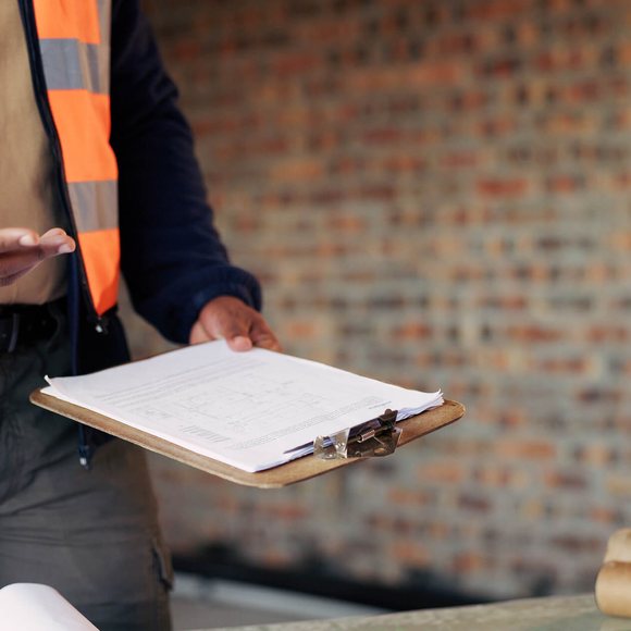 Inspector with a clipboard reviewing maintenance practice